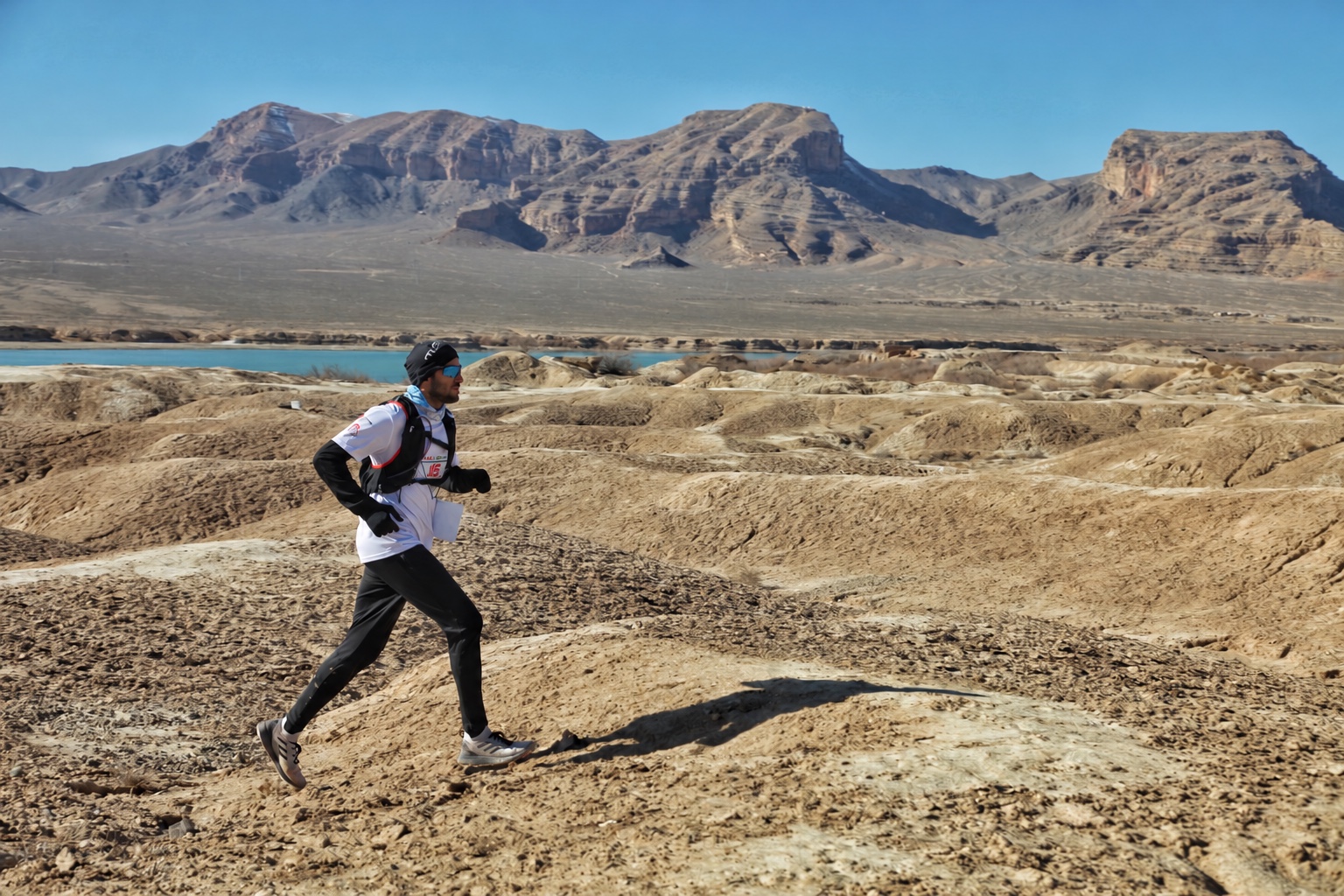Mehran trail running beside a lake and mountains